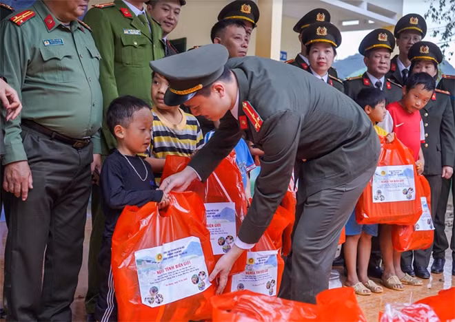 Đoàn viên Đoàn Thanh viên và Hội viên chi hội phụ nữ phòng Tham mưu Công an thành phố Hà Nội trao những món quà nhỏ, khoác áo ấm cho các cháu.