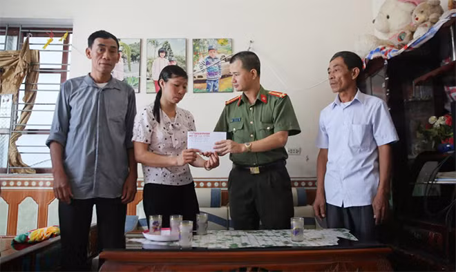 Thượng tá Trần Duy Hiển cùng cán bộ thôn Nội 1 trao tặng số tiền 21 triệu đồng của nhà hảo tâm thông qua Báo CAND hỗ trợ gia đình cháu Phạm Thị Ly
