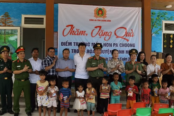 Lãnh đạo Công an tỉnh Quảng Bình và các nhà tài trợ tặng quà cho học sinh Trường Mầm non xã Dân Hóa.