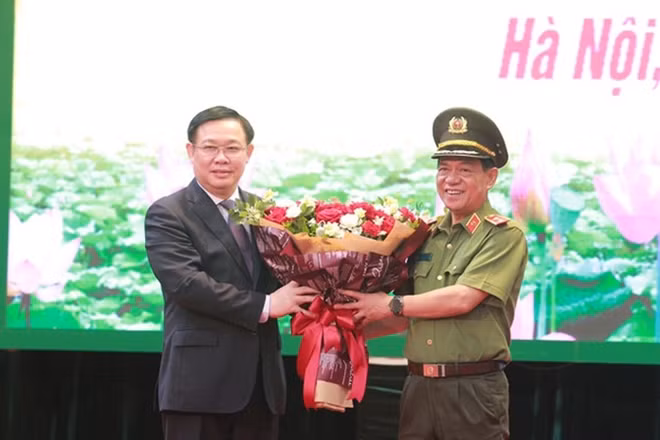 Đồng chí Vương Đình Huệ, Bí thư Thành ủy Hà Nội tặng hoa chúc mừng Trung tướng Đoàn Duy Khương hoàn thành nhiệm vụ.