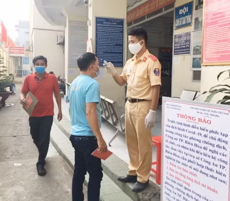 Công an TP. Biên Hòa đo thân nhiệt cho người dân đến liên hệ công việc.