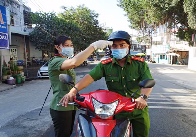 Công an tỉnh Đồng Nai đo thân nhiệt cho CBCS trước khi vào trụ sở làm việc.
