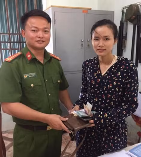 Trung uý Nguyễn Đình Ngân trao trả tài sản đánh rơi cho chị Hướng.