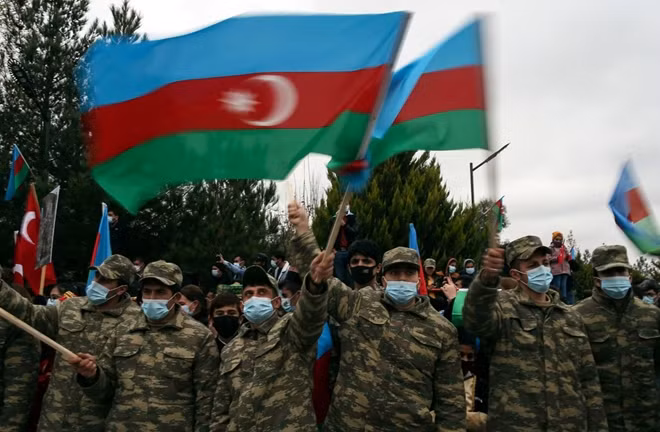 Binh sĩ Azerbaijan vẫy cờ ăn mừng khi tới kiểm soát một khu vực do Armenia trao trả ở Nagorno-Karabakh. Ảnh: AP.
