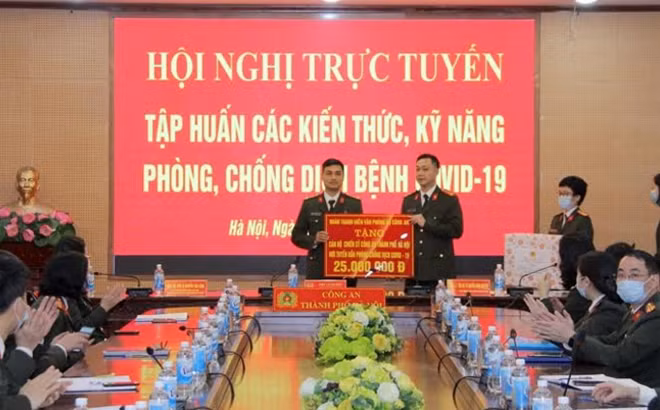 Thượng úy Trần Đăng Biên, Bí thư Đoàn thanh niên Văn phòng Bộ Công an trao tiền và khẩu trang tặng CBCS Công an TP Hà Nội.