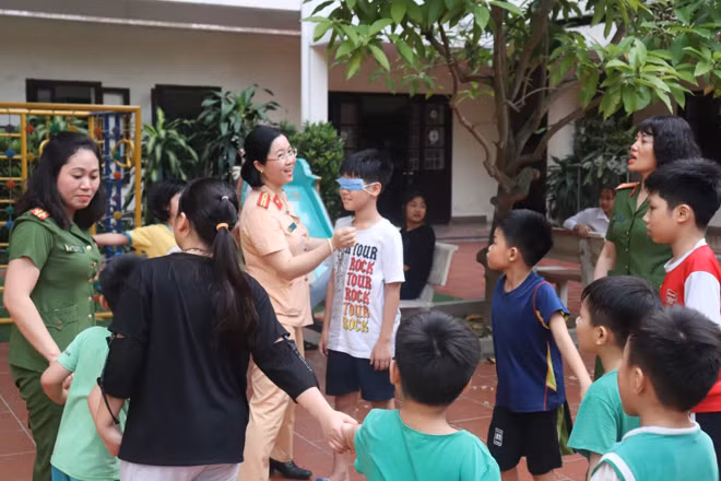 Các nữ CBCS Công an quận Hà Đông trò chuyện, vui chơi cùng các cháu.