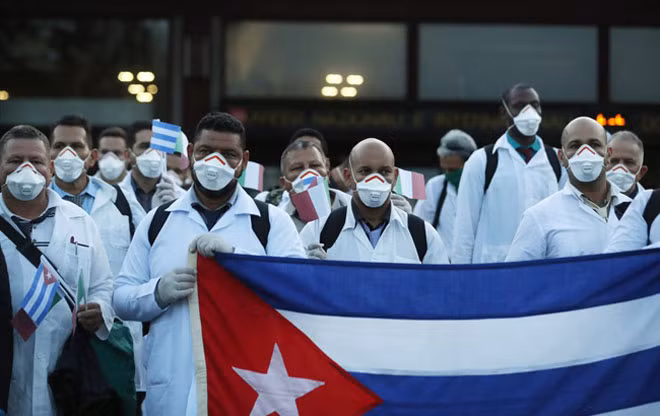 Các bác sĩ Cuba tại sân bay ở Italy, hỗ trợ công tác phòng, chống COVID-19. Ảnh: AP Các bác sĩ Cuba tại sân bay ở Italy, hỗ trợ công tác phòng, chống COVID-19. Ảnh: AP