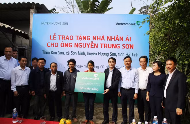 Ông Nghiêm Xuân Thành – Bí thư Đảng ủy, Chủ tịch HĐQT Vietcombank (thứ 5 từ phải sang) trao số tiền ủng hộ của Vietcombank để xây nhà nhân ái cho hộ gia đình ông Nguyễn Trung Sơn tại thôn Kim Sơn, xã Sơn Ninh. Ông Nghiêm Xuân Thành – Bí thư Đảng ủy, Chủ tịch HĐQT Vietcombank (thứ 5 từ phải sang) trao số tiền ủng hộ của Vietcombank để xây nhà nhân ái cho hộ gia đình ông Nguyễn Trung Sơn tại thôn Kim Sơn, xã Sơn Ninh.