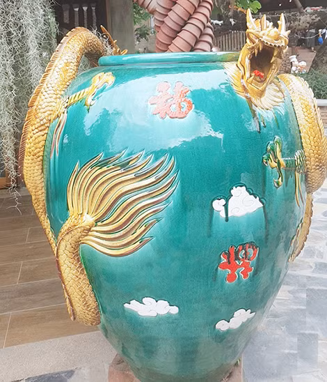 Hình ảnh con rồng và hoa văn trên một bình gốm với chất men màu ngọc lam.