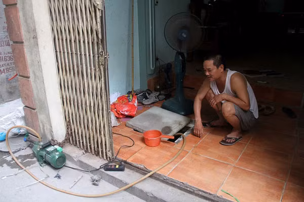 Người dân luôn túc trực bên chiếc máy bơm để chờ nước.