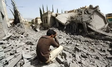 Một người dân Yemen đau khổ đứng trước ngôi nhà bị phá tan bởi tên lửa của Arab Saudi. (ảnh: Reuters).