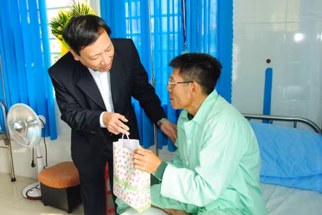 Ông Võ Thành Đông, Phó Chánh Văn phòng Bộ Y tế trao quà của Bộ trưởng Bộ Y tế cho các nạn nhân.