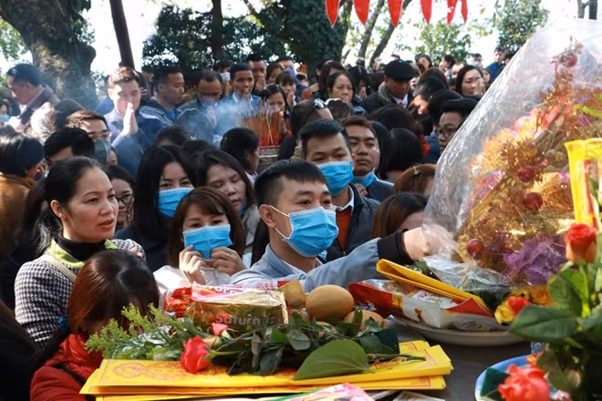 Một nhóm nhân viên văn phòng bịt kín khẩu trang dâng lễ và khấn vái.