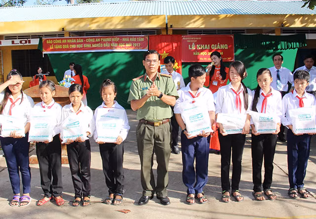 Thượng tá Lê Văn Tiển, Phó trưởng Công an huyện Phụng Hiệp trao tặng tập cho học sinh nghèo vượt khó.