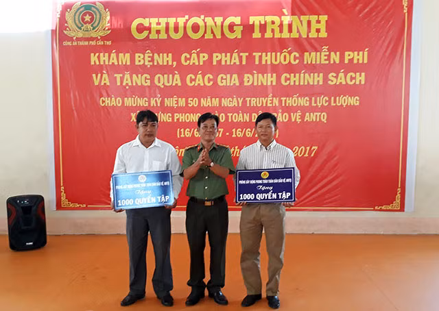 Đại tá Đặng Văn Nỉ, Trưởng phòng Xây dựng phong trào toàn dân bảo vệ ANTQ (PV28) Công an TP Cần Thơ tặng 2000 quyển tập cho học sinh nghèo xã Định Môn.