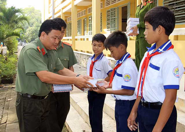 Đại diện Báo CAND động viên, trao tặng tập cho các em học sinh có hoàn cảnh khó khăn tại THCS Phú Mỹ (xã Phú Mỹ, huyện Mỹ Tú, tỉnh Sóc Trăng).