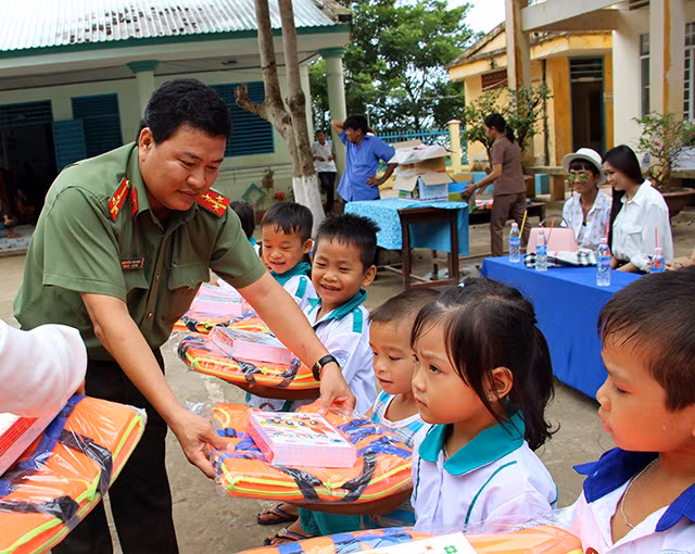Đại diện Báo CAND trao áo phao và tập cho học sinh nghèo tại xã "đầu nguồn" Phú Hội.