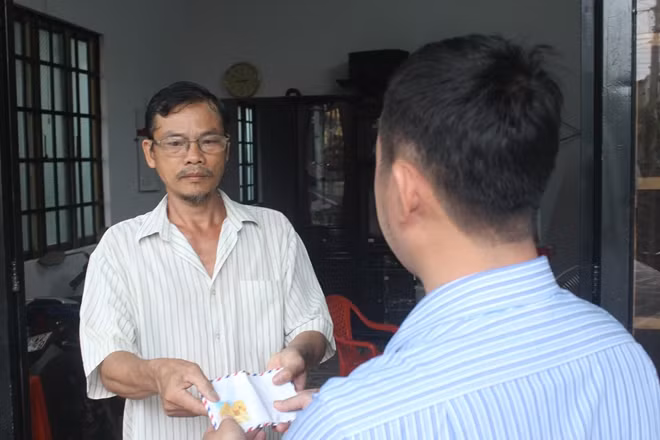 Đại diện Báo CAND trao tiền cho gia đình hiệp sĩ Nam.