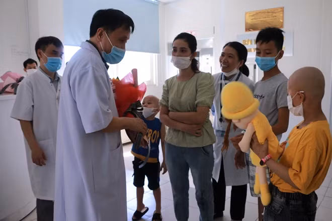 GS.TS Phạm Như Hiệp, Giám đốc Bệnh viện T.Ư Huế tặng hoa cho bệnh nhi Q. lúc xuất viện.