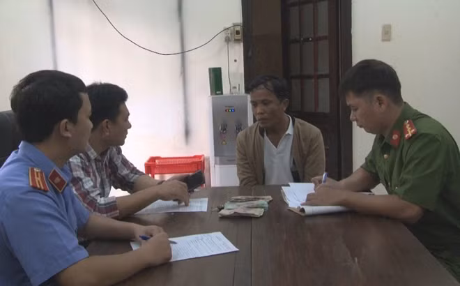 Đối tượng Trần Hưng Việt (mặc áo khoác) tại cơ quan Công an.