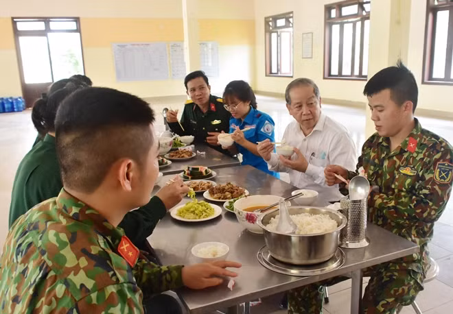 Chủ tịch UBND tỉnh Thừa Thiên Huế (áo trắng) cùng ăn cơm và động viên các CBCS, những người làm công tác hậu cần phục vụ người cách ly.