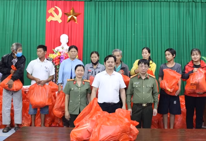 Đại tá Phạm Khải cùng ông Nguyễn Huy Hoàng và đại diện Công an tỉnh Thừa Thiên Huế trao quà cho người dân xã Lộc Bình.