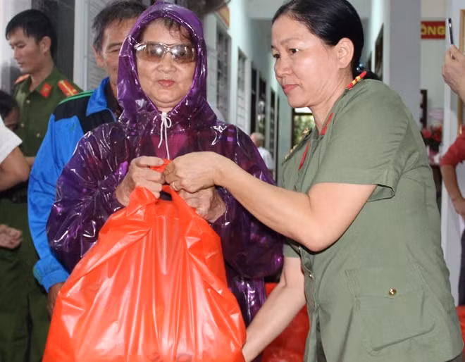 Thượng tá Đinh Thị Sen, Phó Trưởng phòng Công tác Đảng và Công tác Chính trị Công an tỉnh Thừa Thiên Huế trao những suất quà cho người dân ở xã Vinh Hiền.