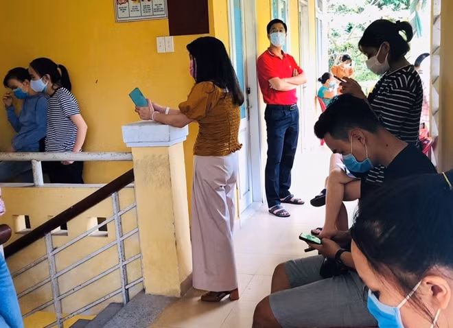 Rất đông người dân ngồi chờ đợi đến lượt nhận mẫu test nhanh COVID-19.