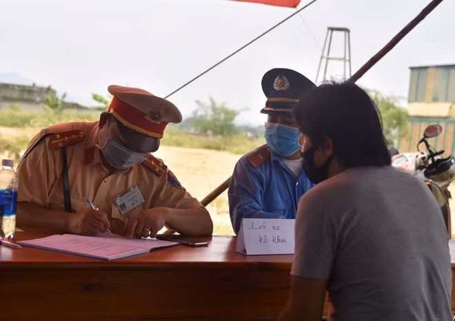 Đại úy Hồ Thanh Hải, Đội số 1 Phòng CSGT Công an tỉnh Thừa Thiên Huế ghi lại thông tin cá nhân các tài xế điều khiển phương tiện qua địa bàn.