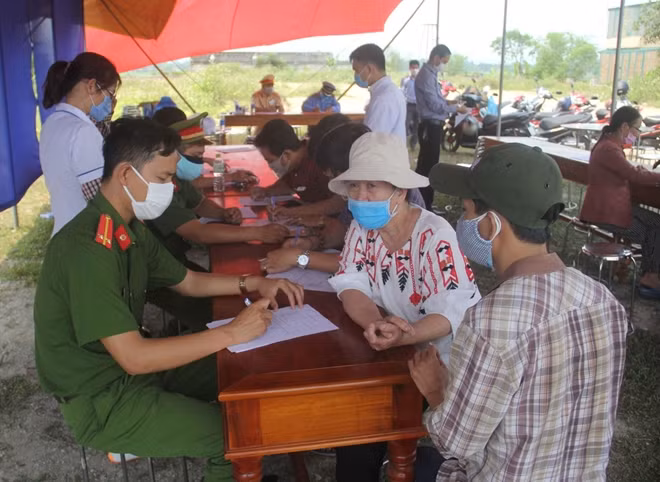 Một CBCS Công an giúp người dân kê khai thông tin vào tờ khai y tế.