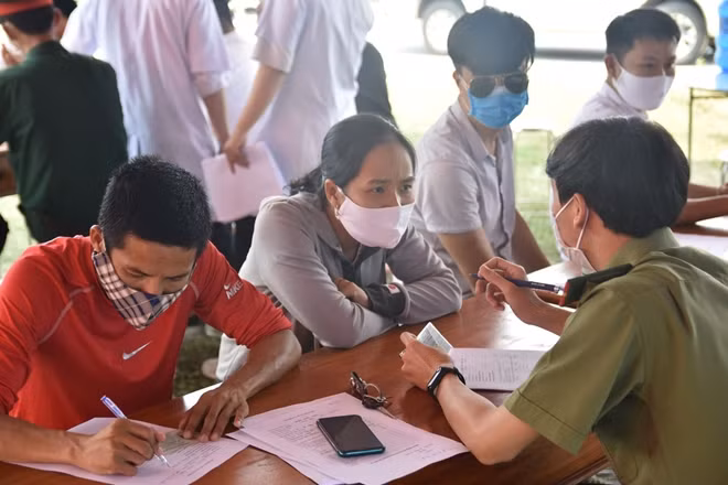 CBCS Công an phối hợp làm nhiệm vụ kiểm tra sức khỏe, viết tờ khai y tế cho người dân tại chốt kiểm soát y tế ở thị xã Hương Trà.