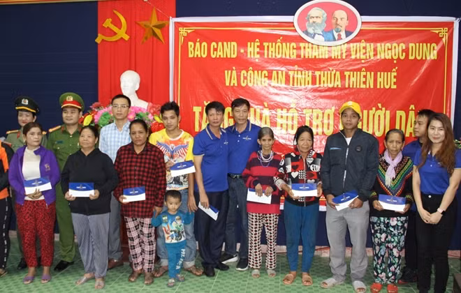 Đại diện Báo CAND, Hệ thống TMV Ngọc Dung và Công an tỉnh Thừa Thiên Huế trao quà cho người dân ở xã Hương Sơn.