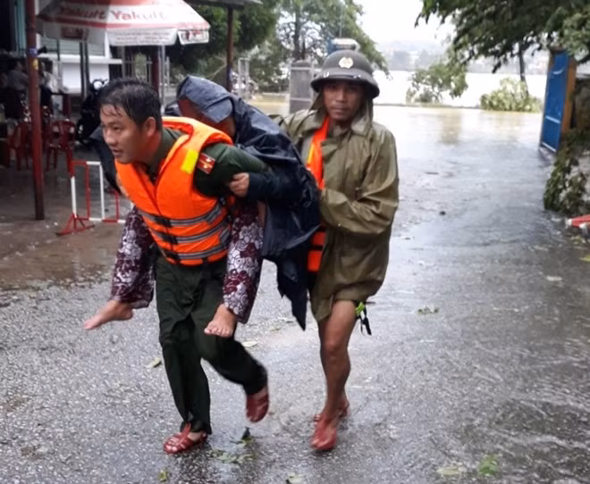 CBCS Công an hỗ trợ, giúp đỡ người dân vượt khỏi vùng ngập lụt đến nơi an toàn.