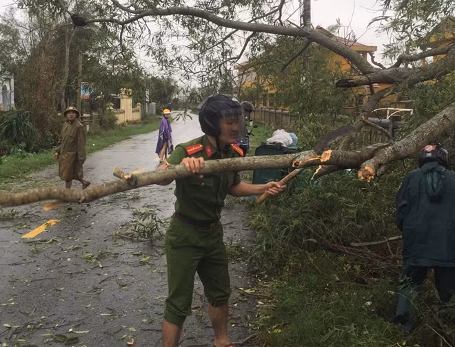 Công an xã Điền Hải, huyện Phong Điền dọn cây xanh gãy đổ chắn ngang đường.