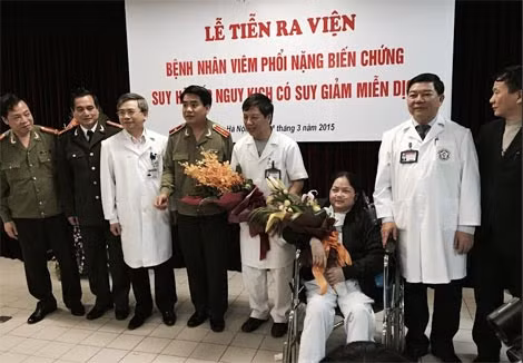 Thiếu tướng Nguyễn Đức Chung tặng hoa và quà cho các thầy thuốc Bệnh viện Bạch Mai và bệnh nhân Đỗ Thị Lượng.
