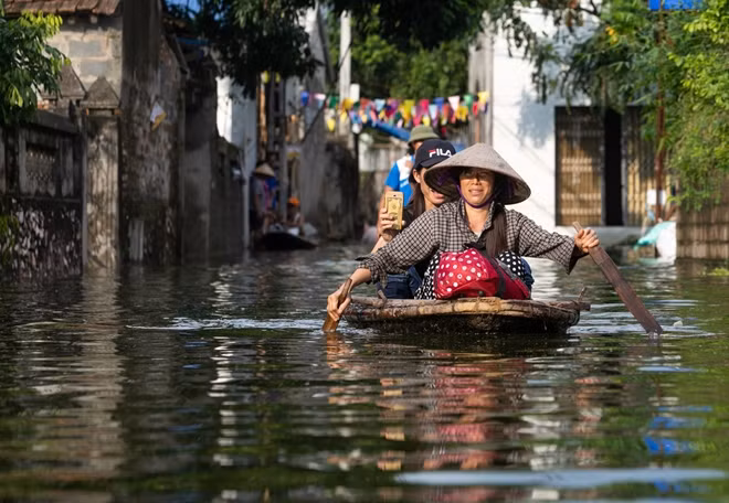 Phương tiện đi lại duy nhất của người dân các xã ngập huyện Chương Mỹ trong những ngày qua. Ảnh: Sơn Châu