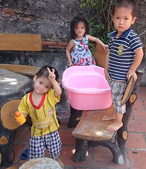 Các bé Tịnh Tâm, Tâm Phúc, Thiện Tâm đang chơi ở sân chùa.