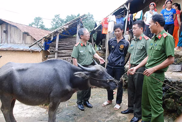Đại tá Đặng Văn Lân, Phó Tổng biên tập Báo CAND thăm hỏi gia đình anh Khoàng Lỳ Phạ ở bản Ka Lăng sau hơn 8 năm được tặng trâu.