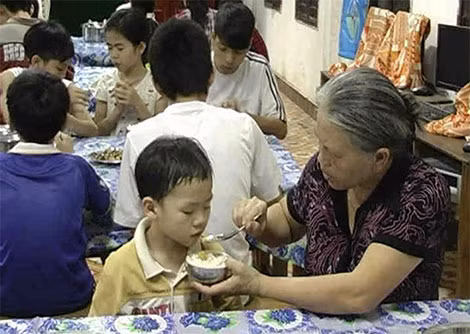 Bà Trần Thục Ninh đang chăm sóc bữa ăn cho một cháu nhỏ.