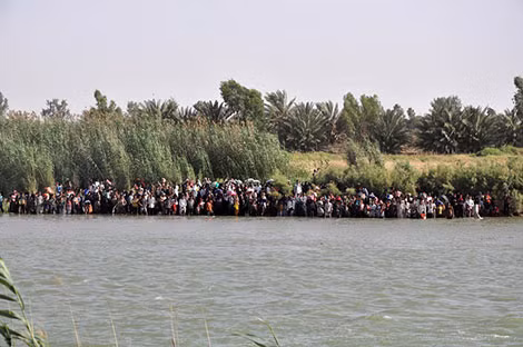 Hàng trăm người dân thành phố Fallujah đứng bên bờ sông Euphrates để chờ cơ hội trốn thoát. Hàng trăm người dân thành phố Fallujah đứng bên bờ sông Euphrates để chờ cơ hội trốn thoát.