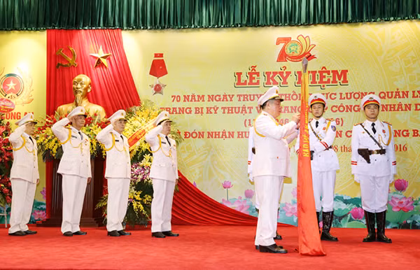 Thừa ủy quyền của Chủ tịch nước, Thứ trưởng Bùi Văn Thành gắn Huân chương lên Cờ truyền thống. Thừa ủy quyền của Chủ tịch nước, Thứ trưởng Bùi Văn Thành gắn Huân chương lên Cờ truyền thống.