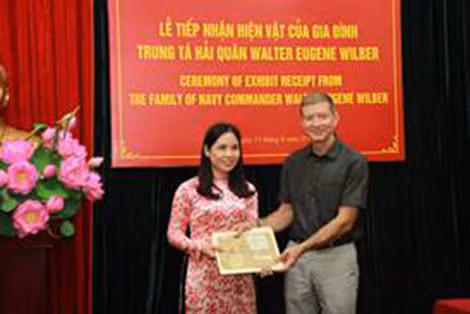 Ông Thomas Eugene Wilber trao tặng kỷ vật của cha mình cho đại diện BQL di tích nhà tù Hỏa Lò.