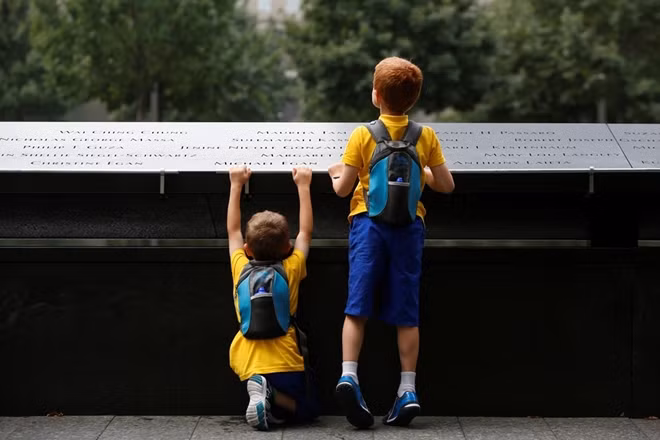 Hai cậu bé đọc tên các nạn nhân ở bia tưởng niệm. 15 năm sau vụ tấn công, vùng Hạ Manhattan đã phục hồi nhanh chóng từ khủng bố, dân số nhiều hơn gấp đôi trong khi tỷ lệ tuyển dụng cũng tăng trưởng, nền kinh tế đa dạng hơn.