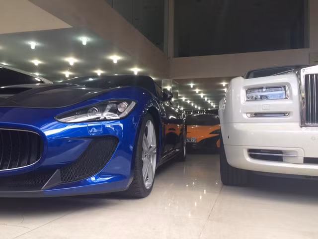 Cặp đôi McLaren 650S Spider màu cam và Maserati GranTurismo MC Stradale màu xanh dương nằm trong salon ô tô.