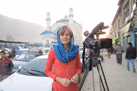 Nhà báo Sally Sara đang tác nghiệp tại thủ đô Kabul (Afghanistan), sau lưng bà là thánh đường Hồi Giáo "Mosque of the King of Two Swords" nổi tiếng.