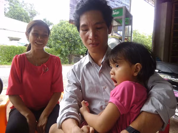 Bé Lan Anh bên vòng tay thương yêu của vợ chồng chị Trang.