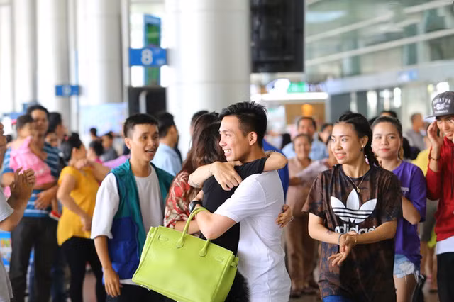 Minh Nhựa và vợ ôm nhau tại sân bay.
