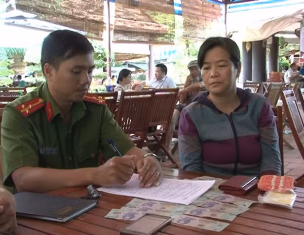 Đối tượng Bằng (bên phải) bị lực lượng Công an bắt quả tang khi đang nhận tiền lừa đảo xin việc.