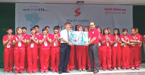 Phạm Ngọc Trình - Phó Bí thư Huyện ủy, Phó Chủ tịch UBND huyện, Trưởng Ban chỉ đạo vận động HMTN huyện Phù Cát (trái) tặng quà cho Đoàn Hành trình đỏ 2015 khu vực miền Nam.