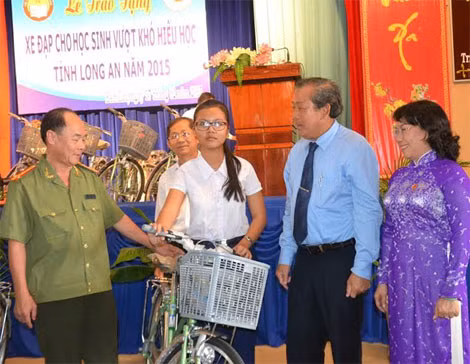 Đồng chí Trương Hòa Bình, Đại tá Trần Kim Thẩm, bà Trần Thị Nhanh, Phó Chủ tịch UBND tỉnh Long An trao xe đạp cho học sinh nghèo.
